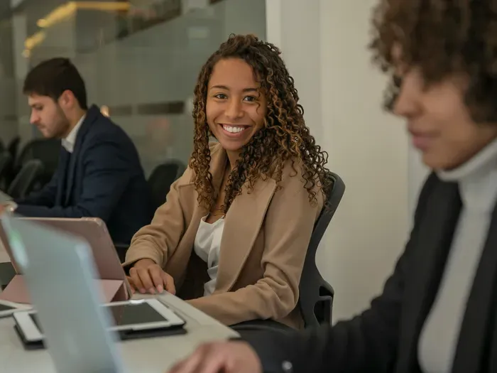 Young professional smiling at a laptop in a bright office, showing helpful support on Local Service Directory Now